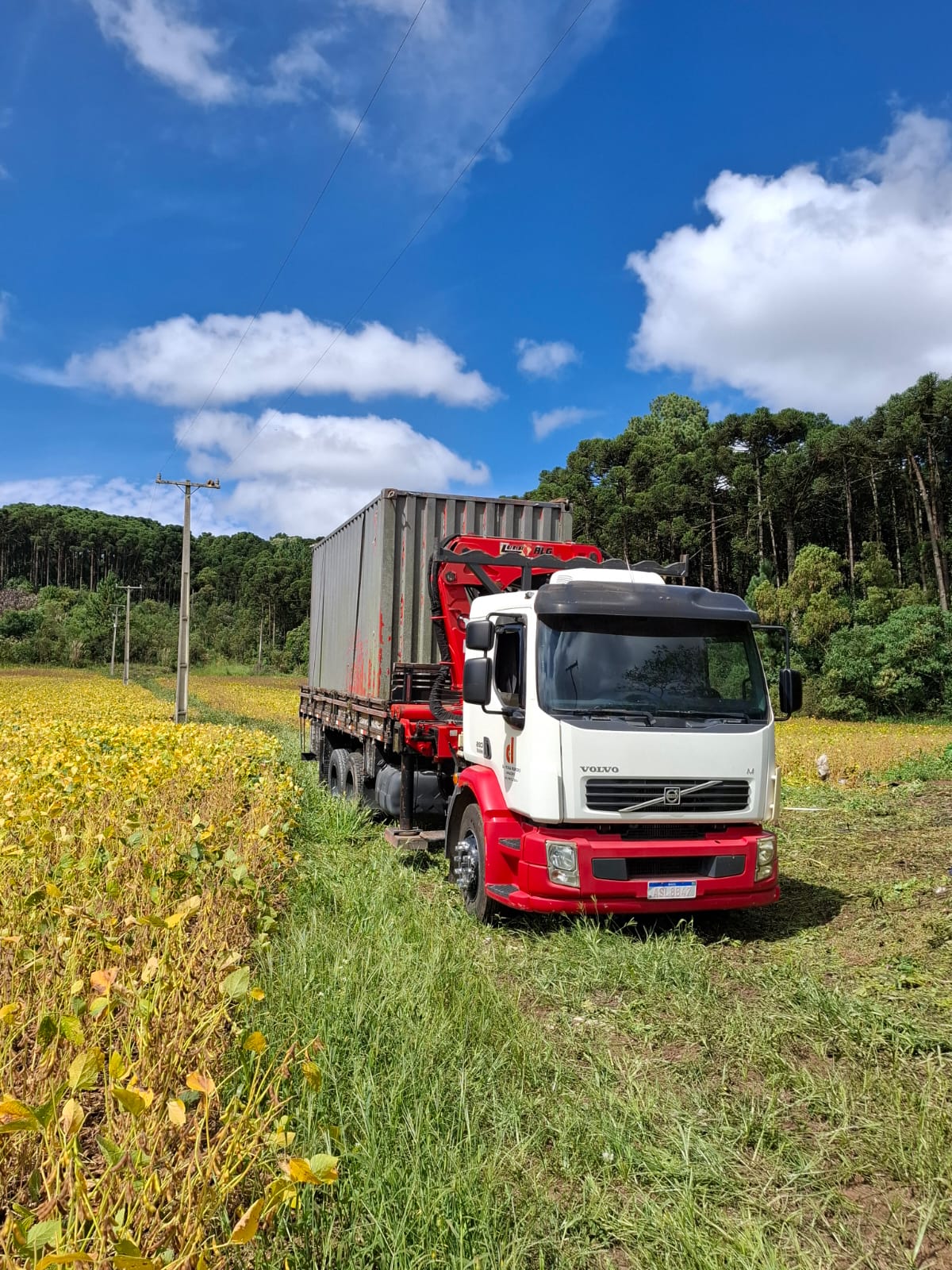 Caminhão munck da Da Veiga em serviço de carga, descarga e transporte de container na região de Curitiba