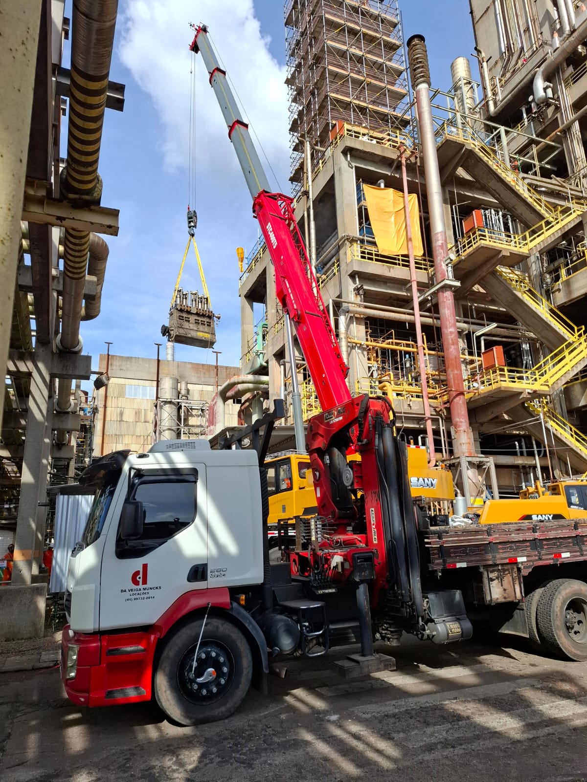 Caminhão munck da Da Veiga Muncks em operação de içamento dentro de planta industrial no Paraná