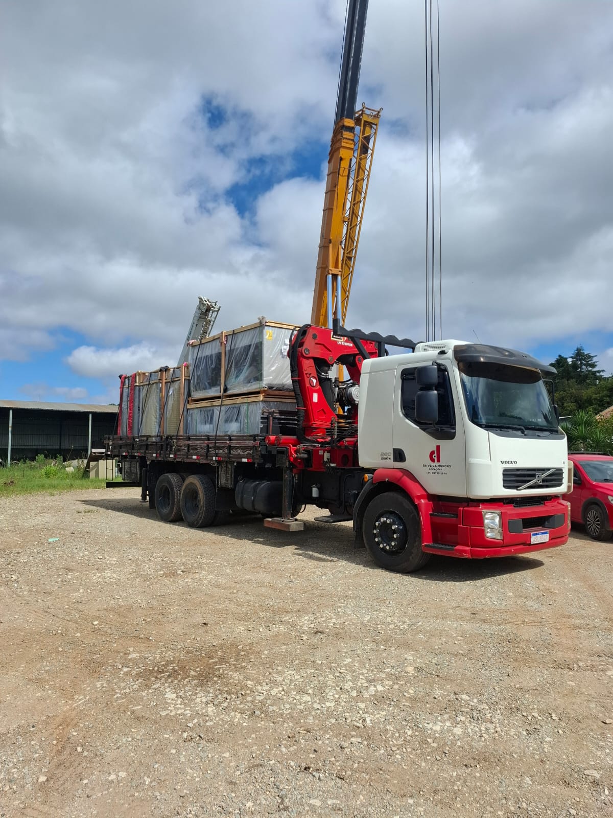Caminhão munck da Da Veiga carregado com equipamentos industriais embalados para transporte em Curitiba